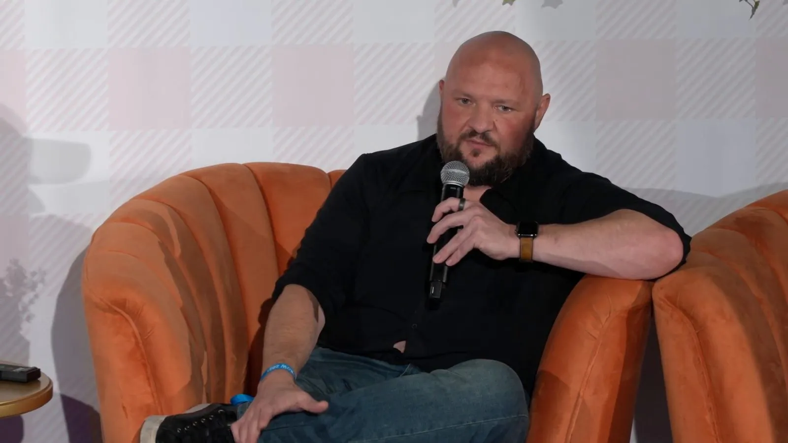 Bryant Garvin seated on stage holding a microphone at GROW NY.